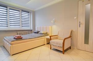 sypialnia z łóżkiem, krzesłem i oknem w obiekcie OMMPBooking w mieście Częstochowa