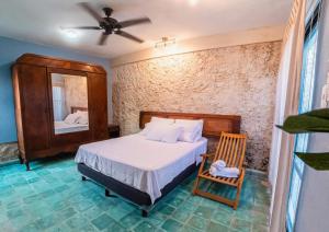 1 dormitorio con cama, espejo y silla en Casona de las Mestizas, en Mérida