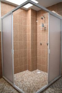 La salle de bains est pourvue d'une douche avec une porte en verre. dans l'établissement Sensity Home habitación elegante, à Tehuacán