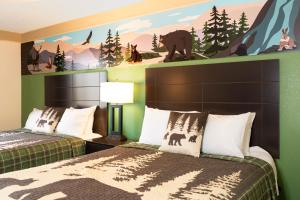 a bedroom with two beds and a mural of bears at Country Cascades Waterpark Resort in Pigeon Forge