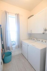 a white kitchen with a washing machine and a window at Waterfront Retreat, Heated Pool, Fishing in Port Charlotte