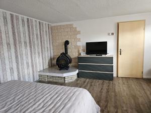 Schlafzimmer mit einem Bett und einem Flachbild-TV in der Unterkunft Haus Alva in Ahlbeck