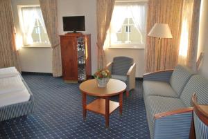 a hotel room with a couch and a table at Hotel-Gasthof Maisberger in Neufahrn bei Freising