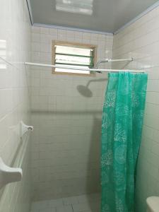 baño con ducha con cortina azul en Bread Fruit Lodge, en San Andrés