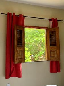 een raam met een rood gordijn in een kamer bij Sítio Primavera in Ipueiras