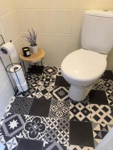 a bathroom with a toilet and a black and white tile floor at Apartmán vo vidieckom dome in Malá Tŕňa