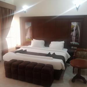 una habitación de hotel con 2 camas y una silla en Desikok Royal Hotel LTD, en Port Harcourt