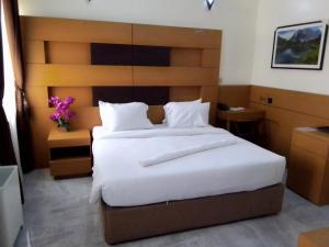1 dormitorio con 1 cama grande con sábanas blancas en Desikok Royal Hotel LTD, en Port Harcourt