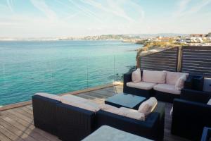 d'un balcon avec des canapés et une vue sur l'eau. dans l'établissement Villa luxe vue mer panoramique - sauna-hamam - jacuzzi, à Marseille