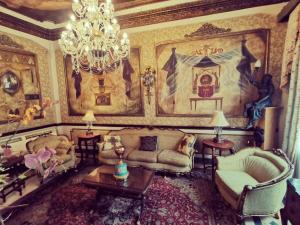 a living room with a chandelier and a couch and chairs at Hotel Boutique Mansion Del Rio in Guayaquil