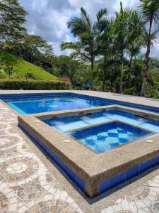 a swimming pool with blue water in a patio at Hacienda la riviera in Santa Rosa de Cabal