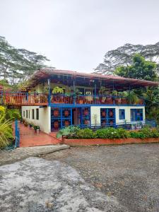 a house with a balcony on top of it at Hacienda la riviera in Santa Rosa de Cabal
