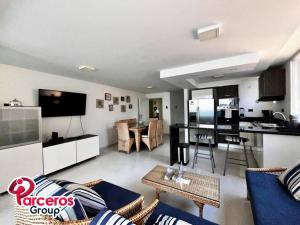 a living room with a blue couch and a kitchen at Acogedor Apartamento Para Grupos Cerca Al Mar Por Parceros Group in Cartagena de Indias