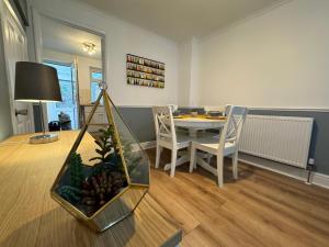 a living room with a dining room table with a fish tank at Cosy home with parking close to city centre in Exeter
