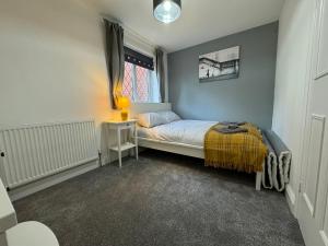 a small bedroom with a bed and a window at Cosy home with parking close to city centre in Exeter