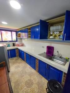 a kitchen with blue cabinets and a sink at Hacienda la riviera in Santa Rosa de Cabal
