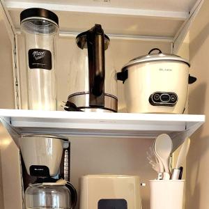 a shelf with a coffee pot and other kitchen items at Cozy Minimalist Unit at BGC Mall Free Parking in Manila