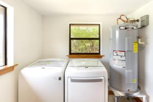 a small kitchen with a refrigerator and a window at Get Back to Nature at Secluded Hill Country Oasis in Driftwood