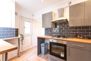 a kitchen with stainless steel appliances and wood floors at Stylish 1-Bed Flat in Liverpool by 53 Degrees Property, Ideal for Business & Long-Term Stays! in Liverpool