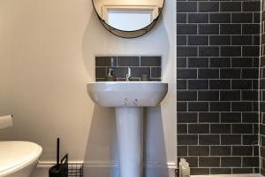 リバプールにあるStylish 1-Bed Flat in Liverpool by 53 Degrees Property, Ideal for Business & Long-Term Stays!の洗面台と壁に鏡が付いたバスルーム