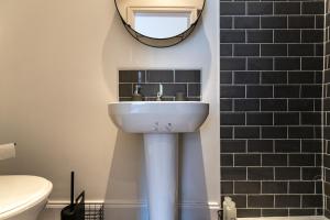 a bathroom with a sink and a mirror on the wall at Stylish 1-Bed Flat in Liverpool by 53 Degrees Property, Ideal for Business & Long-Term Stays! in Liverpool