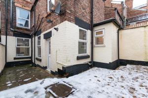 リバプールにあるStylish 1-Bed Flat in Liverpool by 53 Degrees Property, Ideal for Business & Long-Term Stays!の雪の降るアパートメントビル