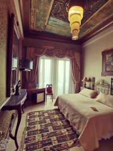 a bedroom with a bed and a desk and a window at Hotel Boutique Mansion Del Rio in Guayaquil