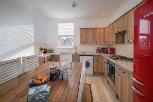 una cocina con armarios de madera y una mesa con pan. en The Chambers Apartment, spacious 4bed duplex en Cowes