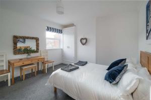 1 dormitorio con cama y escritorio con espejo en The Chambers Apartment, spacious 4bed duplex en Cowes