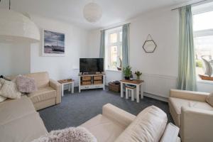 sala de estar con muebles blancos y TV de pantalla plana en The Chambers Apartment, spacious 4bed duplex en Cowes