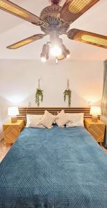 1 dormitorio con 1 cama azul y ventilador de techo en Atlantico Flamingo, en Calpe