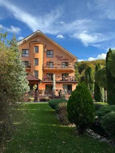 a large building with a garden in front of it at Pensiunea Roua Muntilor in Vadu Crişului