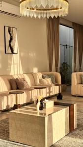 salon z kanapą i stołem w obiekcie شالية سَال الفندقي w mieście Burajda