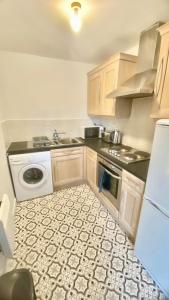 a small kitchen with a sink and a dishwasher at Spacious 1 Bedroom Apartment In Wigan in Shevington
