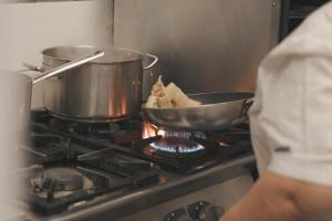 a person cooking food in a pot on a stove at Agriturismo Il Tintore in Tramonti +22 photos