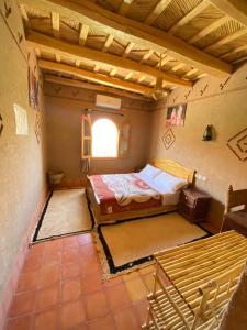 Großes Zimmer mit einem Bett und einem Fenster in der Unterkunft Gîte d'étape Tamaloute in Bou Drarar