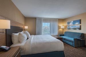 a hotel room with a bed and a blue couch at TownePlace Suites by Marriott Columbia in Columbia