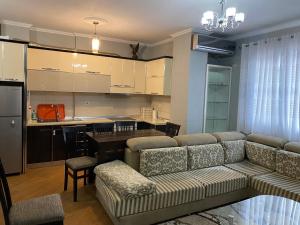 a living room with a couch and a kitchen at Comfortable 2-BR for 5 in Tirana