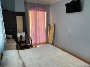 ein kleines Schlafzimmer mit einem Bett und einem Fenster in der Unterkunft Comfortable 2-BR for 5 in Tirana
