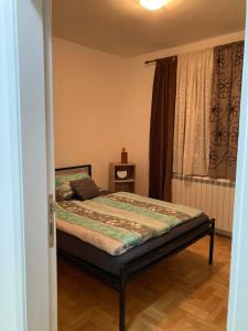 a small bedroom with a bed and a window at Tea in Sremska Mitrovica
