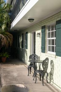 a patio with two benches and a table on a porch at French Quarter Suites Hotel in New Orleans