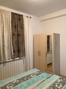 a bedroom with a bed and a cabinet and a window at Tea in Sremska Mitrovica