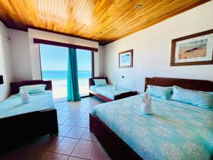 a bedroom with two beds and a view of the ocean at Hotel Sierra Negra in Puerto Villamil