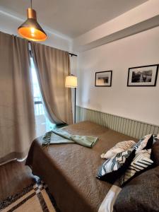 a bedroom with a bed with a lamp and a window at Cafofinho Decor in Sao Paulo +40 photos