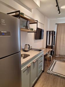 a kitchen with a stainless steel refrigerator and a table at Cafofinho Decor in Sao Paulo