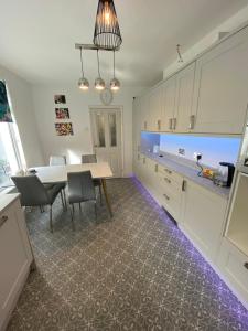 Una cocina con una mesa y sillas en una habitación. en Kingfisher En-suite Room, en Plymouth 14 fotos más