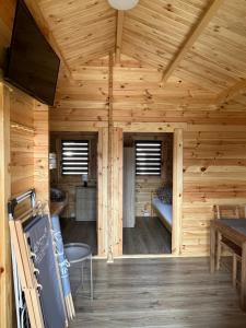 eine Blockhütte mit einem Zimmer mit einem Bett darin in der Unterkunft Bałtyckie Klimaty in Gąski