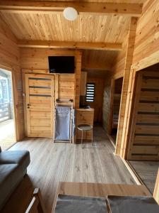 ein Zimmer in einem Blockhaus mit einem Sofa und einem Tisch in der Unterkunft Bałtyckie Klimaty in Gąski