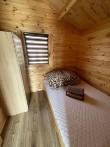 a room with a bed in a wooden cabin at Bałtyckie Klimaty in Gąski