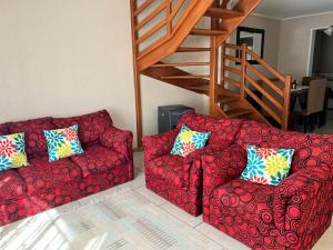 een rode bank en een stoel in de woonkamer bij Amplia Casa 8 dormitorios 4 baños Avenida Lircay in Talca
